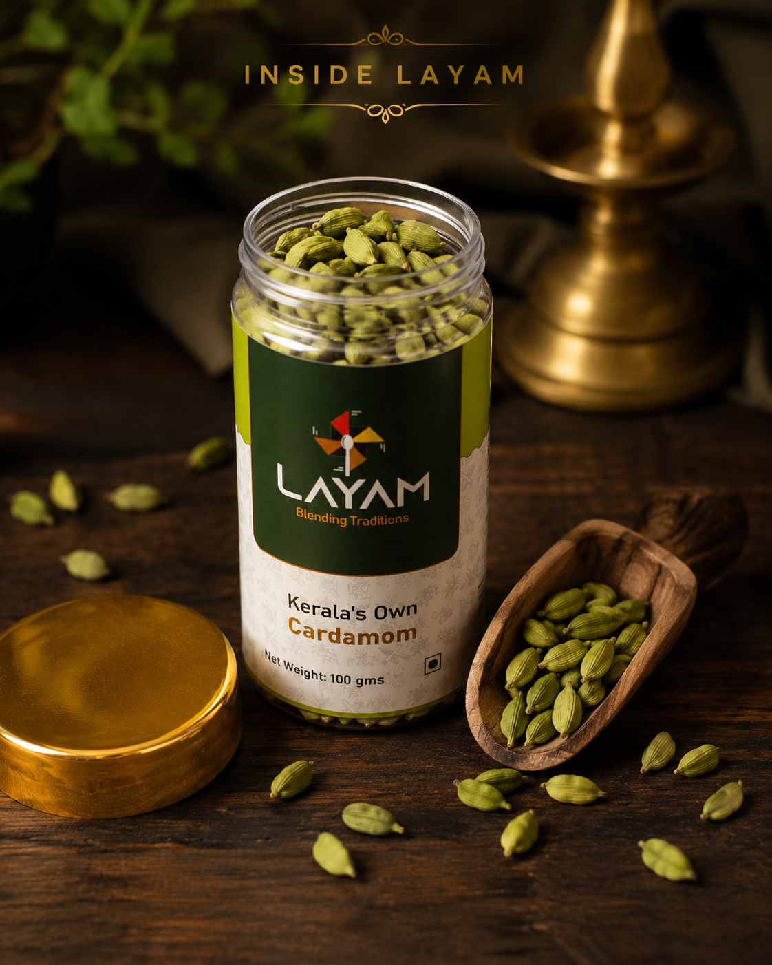 Open LAYAM cardamom jar showing whole green pods inside, with a wooden scoop