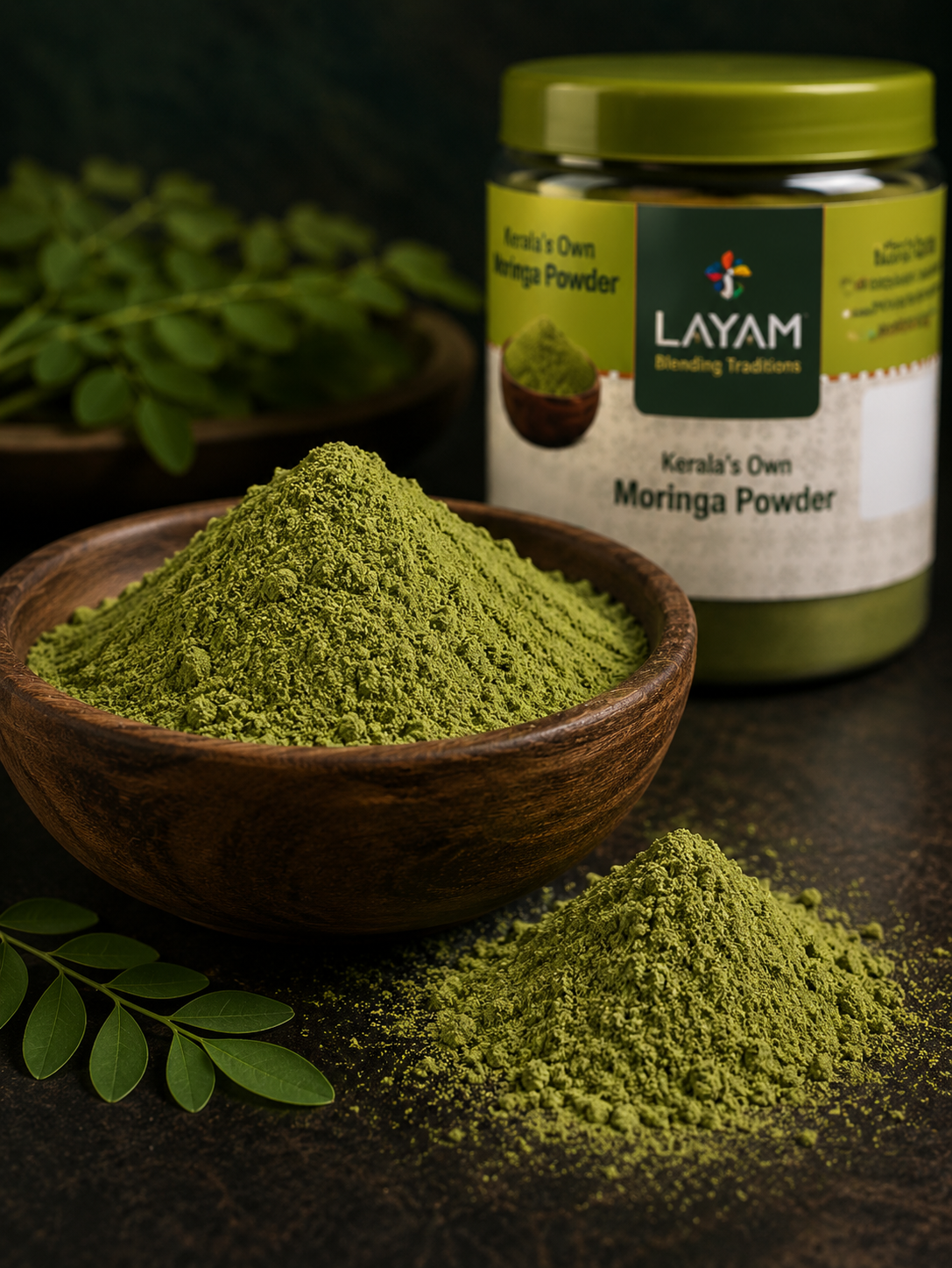 Close-up of fine green LAYAM moringa powder in a wooden bowl beside the jar and fresh leaves
