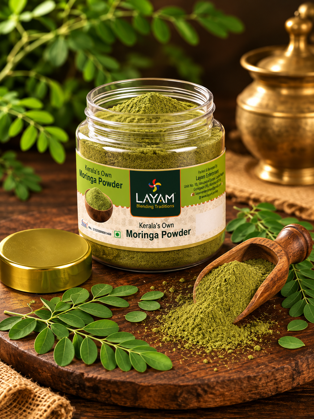 Open LAYAM moringa powder jar showing fine green powder inside, with a wooden scoop and fresh leaves